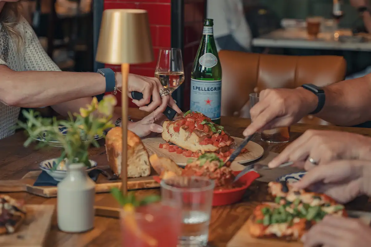 people cut food on a table at Mia’s Italian Kitchen