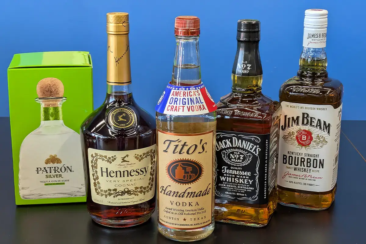 Bottles of Patron, Hennessy, Tito's, Jack Daniel's, and Jim Beam
