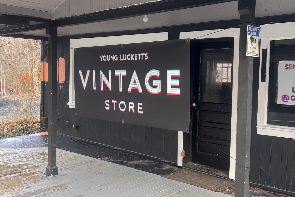a sing for Young Lucketts Vintage Store hangs outside a building