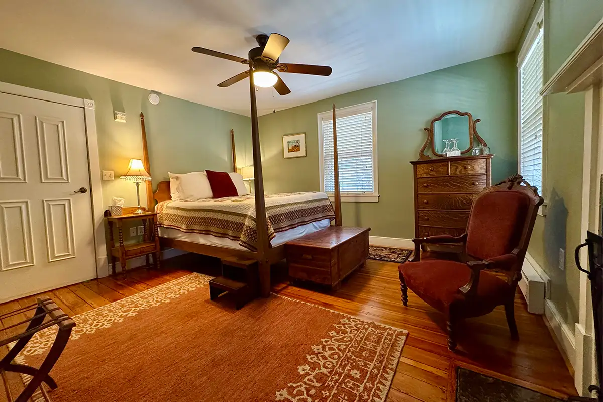 A bedroom with a bed, rug, ceiling fan and antique furniture at Hopkins Ordinary B&B in Sperryville