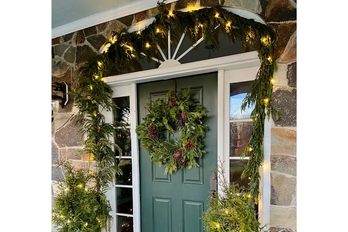 a front door with a holiday wreath and garland