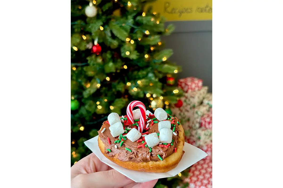 a Yoder’s Dutch Delights holiday doughnut in front of a Christmas tree