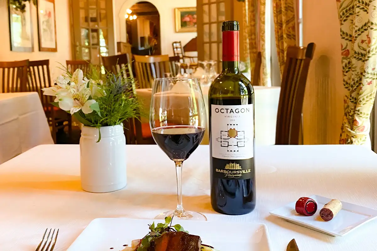Barboursville’s Octagon 2017 wine sits on a table poured in a wine glass next to the bottle