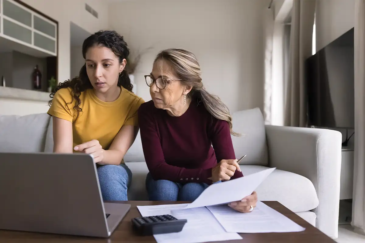 Mom looking at financial paperwork with adult daughter
