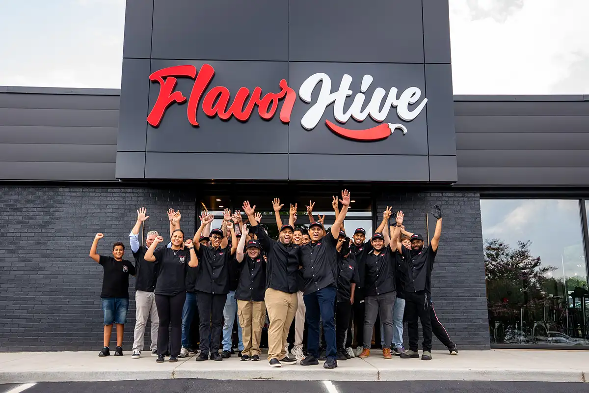 Flavor Hive workers posing outside storefront