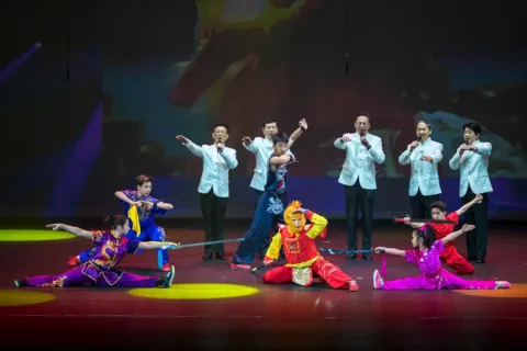Performers singing and dancing on stage at a Lunar New Year performance at Capital One Hall.