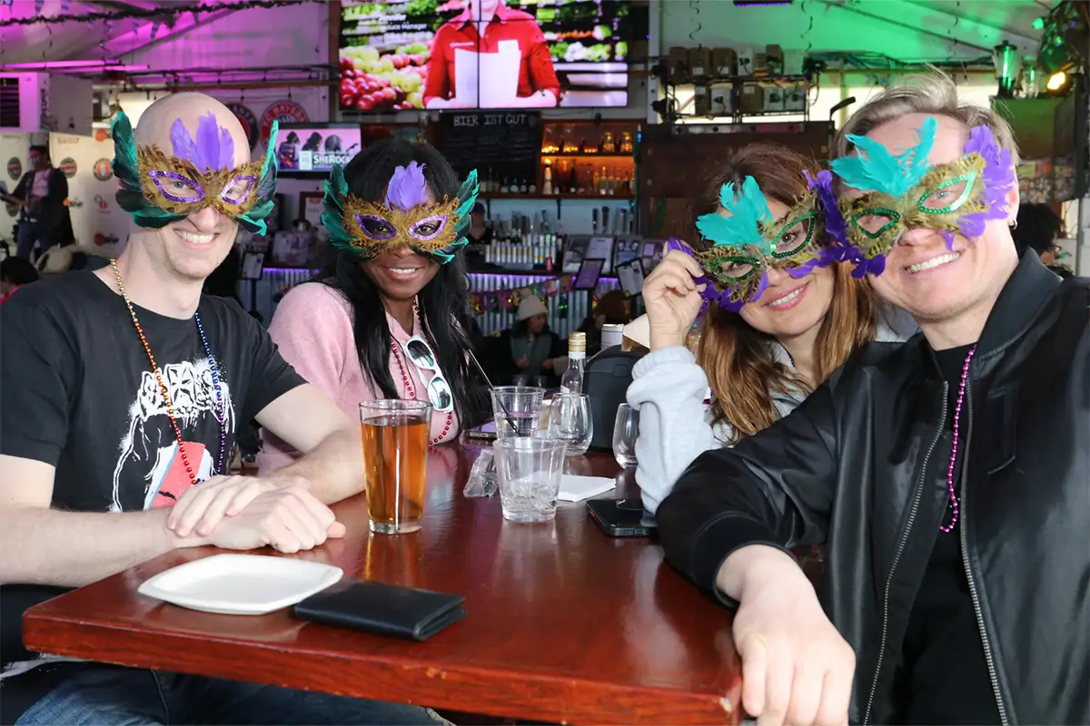 people sitting at a table wearing Mardi Gras masks