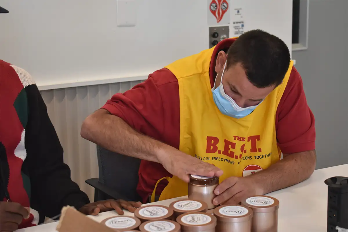 a employee at the BEST program in Old Town Alexandria works to make candles