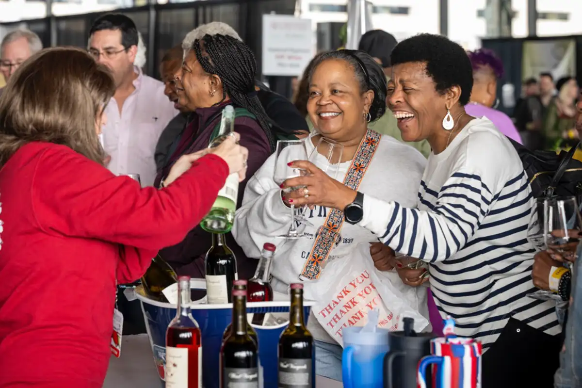 women are poured wine samples at the Virginia Wine Expo