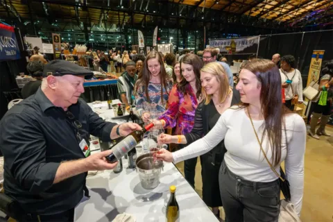 a staff member pours wine samples for attendees at the Virginia Wine Expo