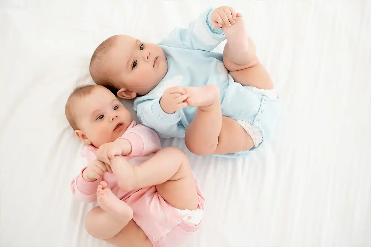 boy and girl baby laying on backs