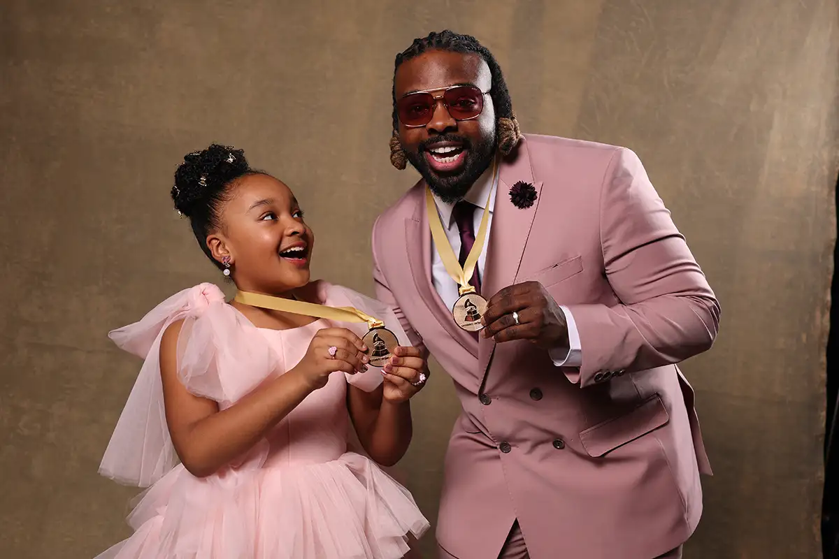 Aura V and her father Fyütch dressed up in pink hold their Grammy medals