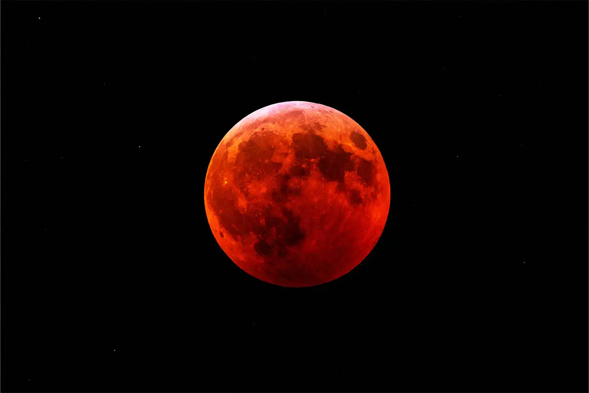 a blood moon against the night sky