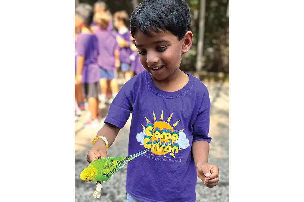 Child with parakeet at Camp Griffin