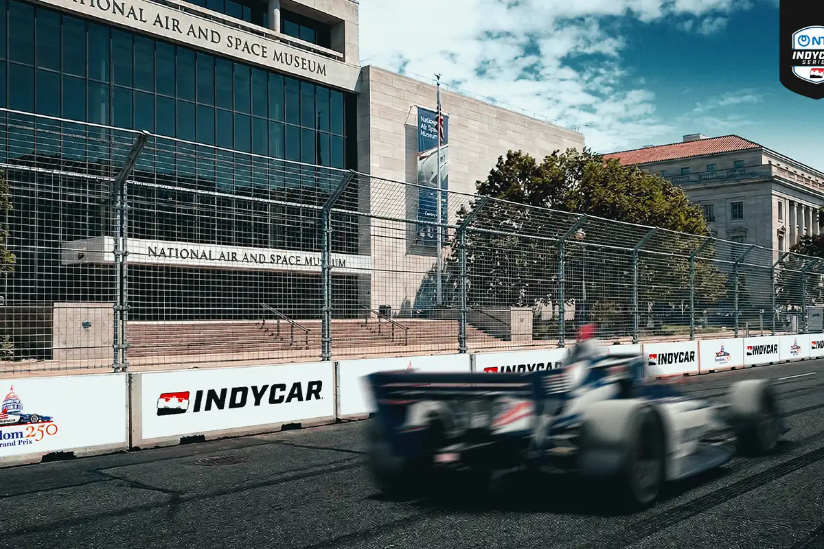 a rendering of a race car driving in front of the Smithsonian Air and Space Museum