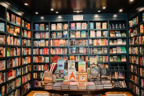 Books on shelves and stacked on a table inside Middleburg Books