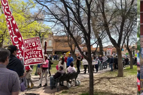 people sit and march at a No Kings rally