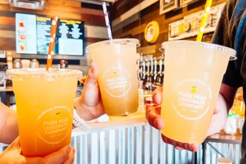 people hold three lemonade drinks
