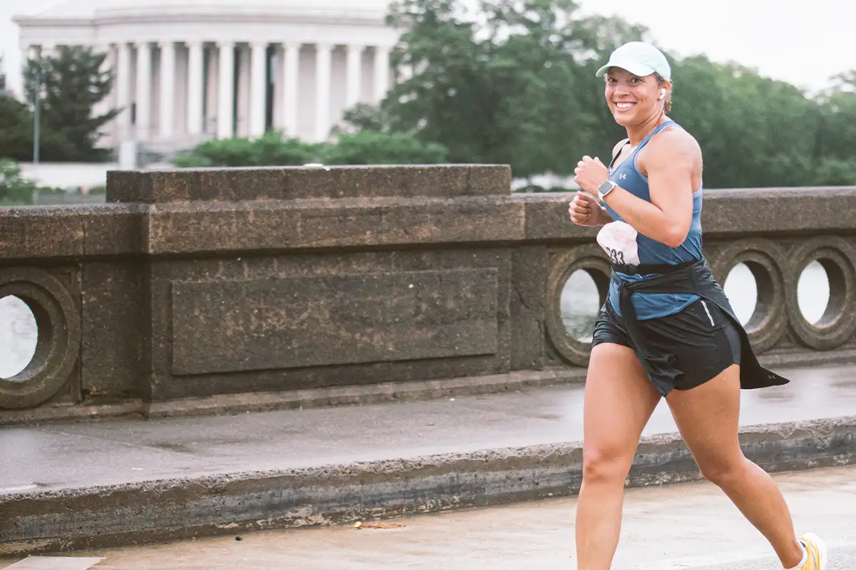 a runner runs by the monuments in DC during the National Women’s Half
