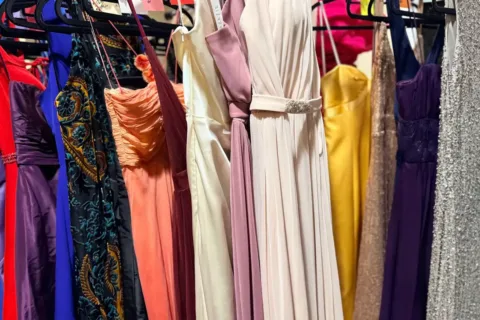 donated prom dresses hang on a rack