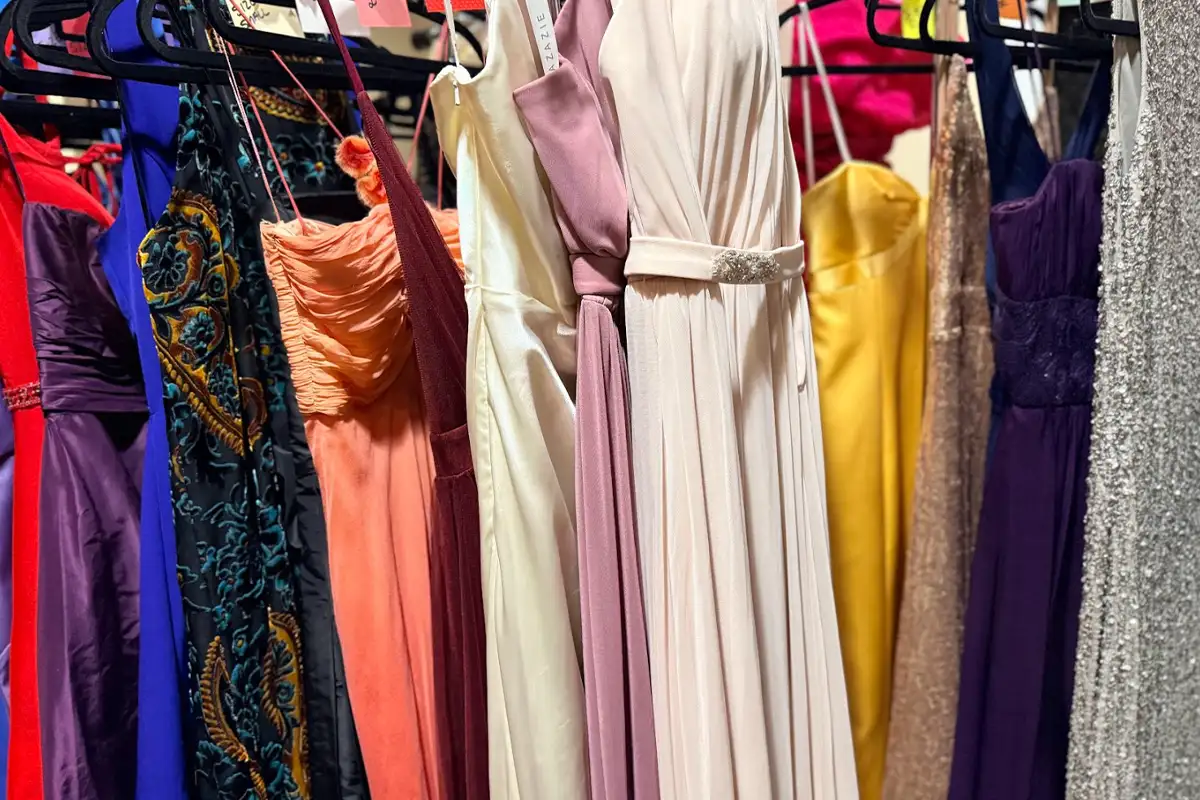 donated prom dresses hang on a rack