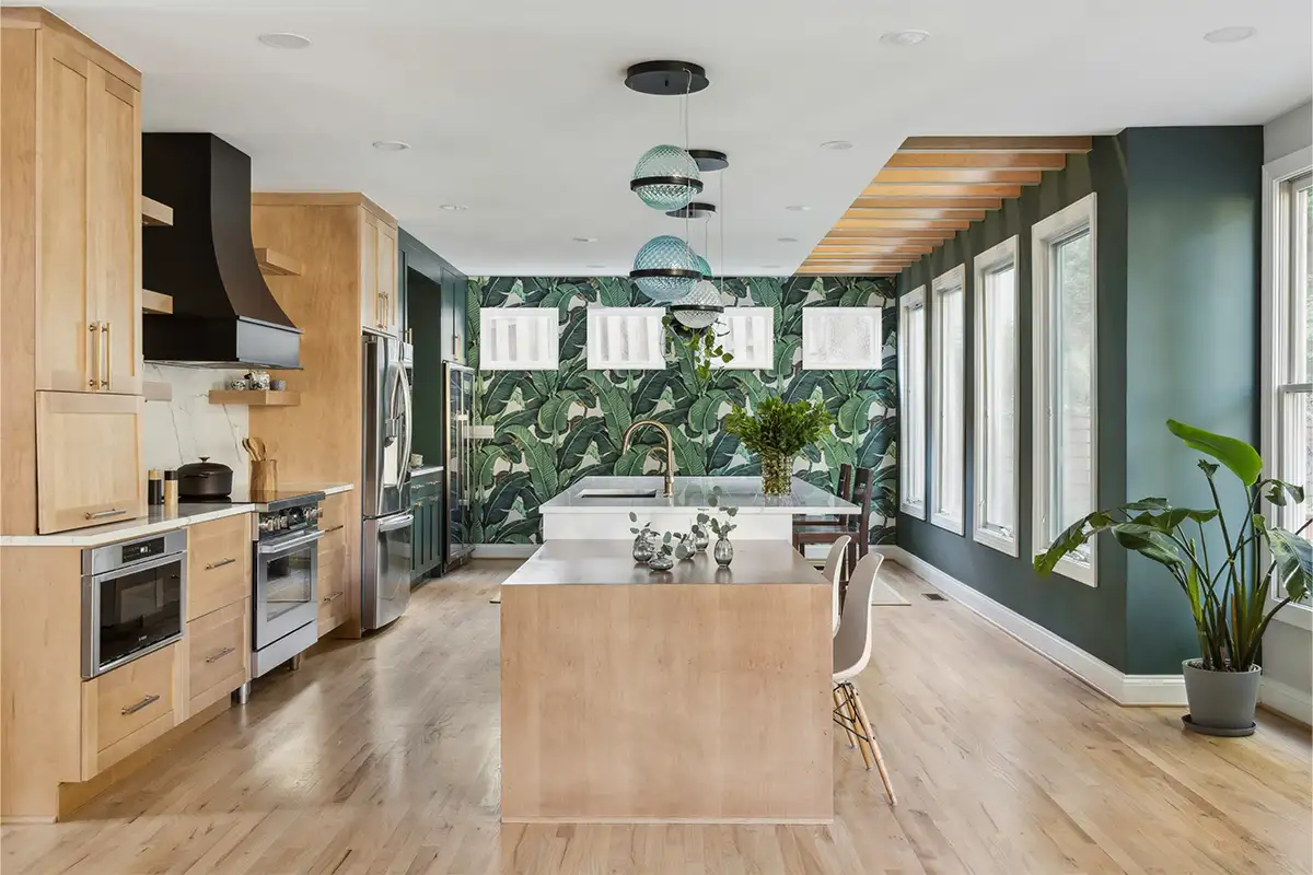 Green banana leaf accent wallpaper in open kitchen with green walls and plants