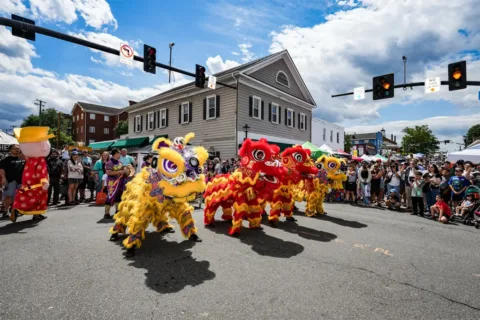 Crowd watching dragon dance on the street at Asian Festival on Main
