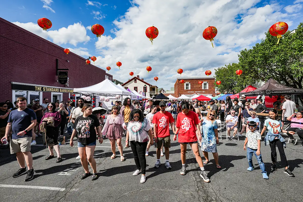 people learn dance steps in the street at the Asian Festival on Main in Fairfax