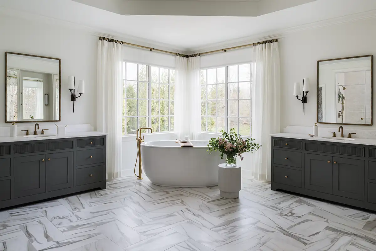 Custom cabinetry was designed by Maurie Minichiello Design, and crafted by Unique Kitchens and Baths, with mirrors from Safavieh. The tub filler is by California Faucets. 