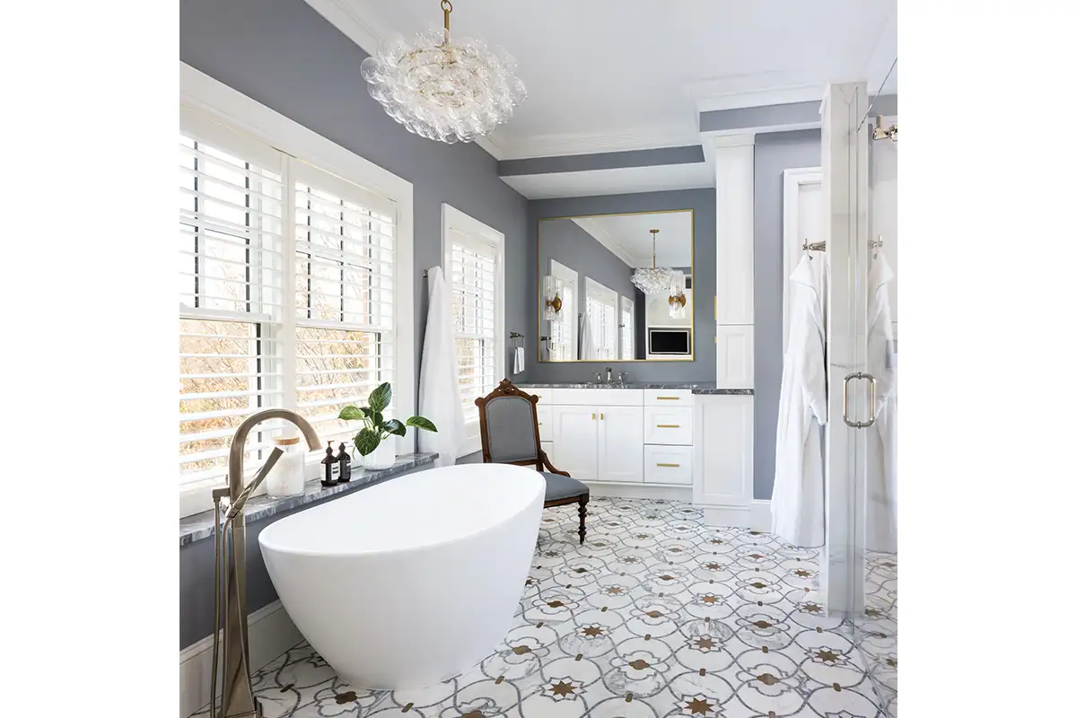 A Bubbles chandelier from Regina Andrews floats above a freestanding bathtub. The hardware is from Push Pull Hardware, and flooring was done in collaboration with Marble Systems.