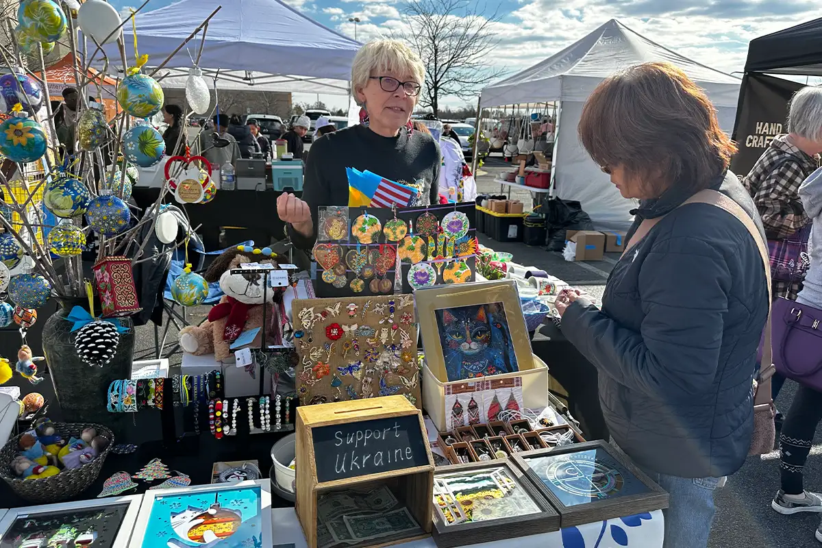 a vendor talks with a customer at the Loudoun Spring Market at the Dulles Town Center