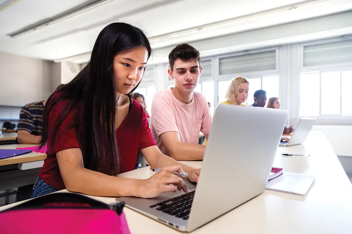 Kids using laptops in school