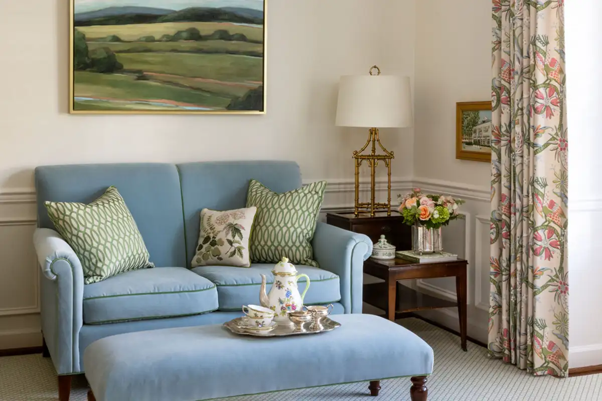 Interior living room with light blue velvet sofa and wainscotting of the Merchant family home in Alexandria