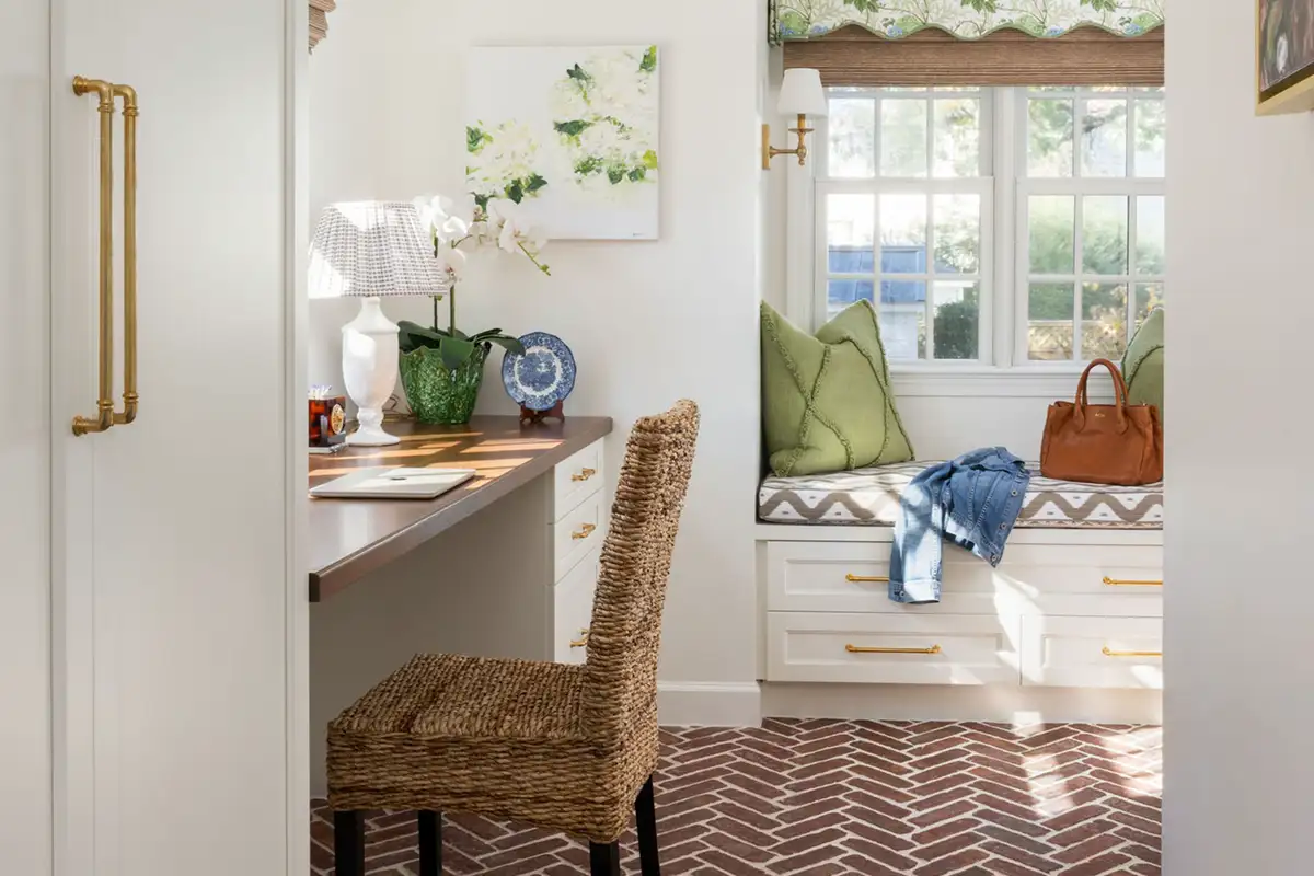 Mudroom interior with a wicker chair and window seat of the Merchant family home in Alexandria
