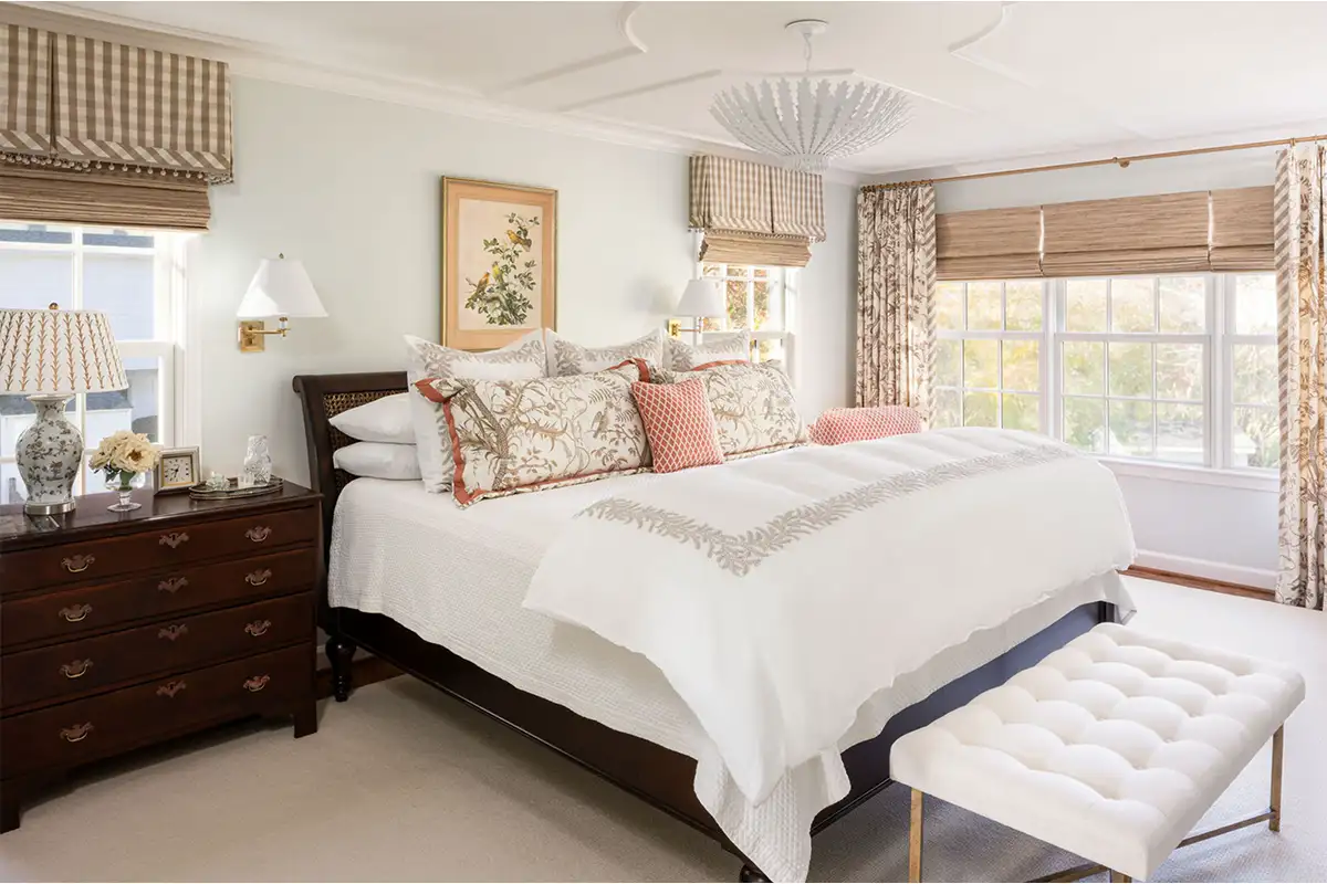 Bedroom interior with dark wood furniture and bright floral decor of the Merchant family home in Alexandria