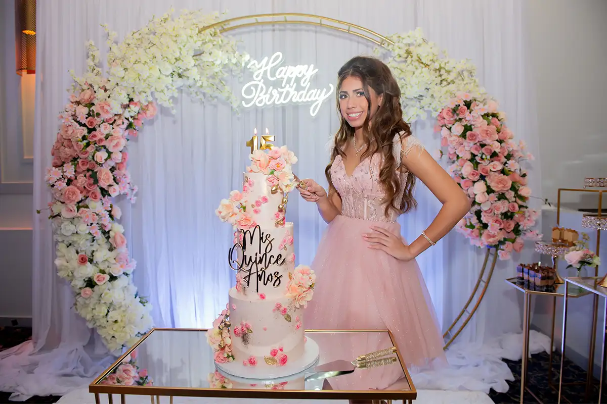 Taliana Ibanez posing cutting cake at her quinceañera
