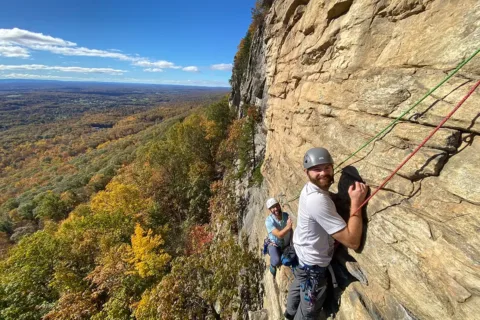 Two men posing while rock climbing at New York's Shawangunk Ridge