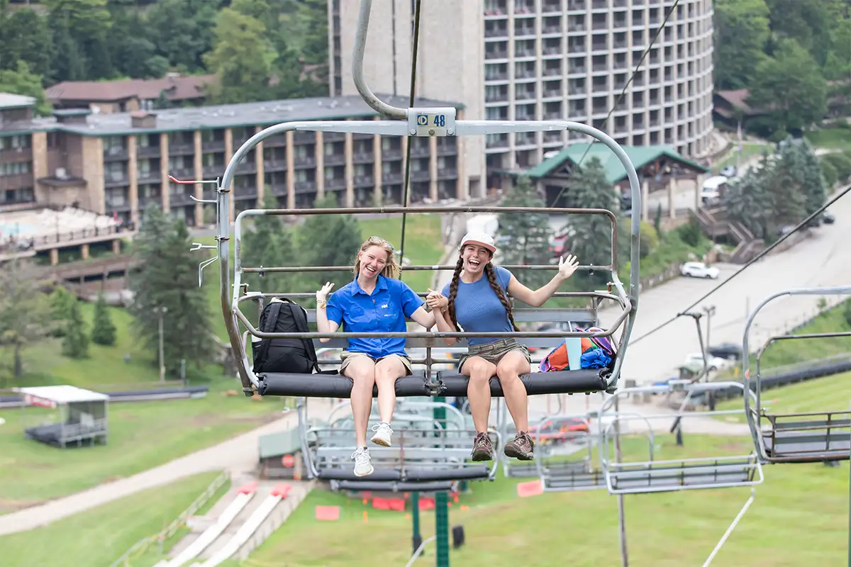 Two girls posing on a chair lift with Seven Springs Mountain Resort in Pennsylvania