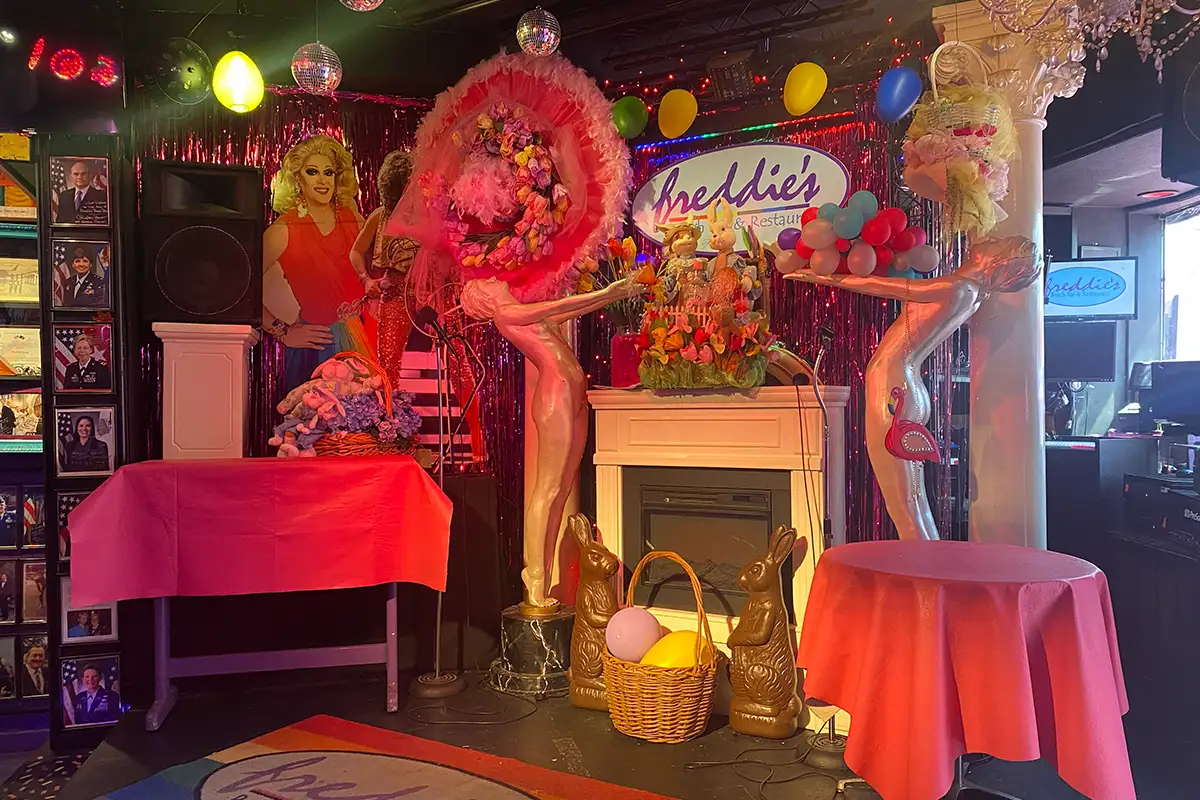Stage area of Freddie's Beach Bar with statues, pink decor, and Easter decorations