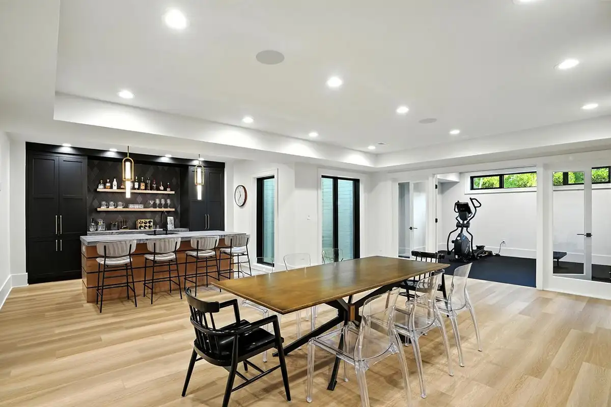 Finished basement with a custom bar, home gym, guest room, full bath, powder room, and family room with a fireplace of 1200 Jossie Lane.