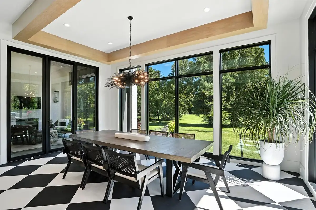 Dining room with floor to ceiling windows, checkered floors, and high ceiling of 1200 Jossie Lane.