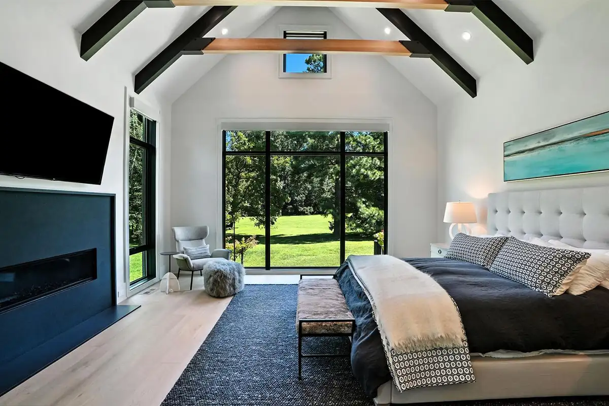 Primary bedroom with vaulted, beamed ceiling, a fireplace, two walk-in closets, and private laundry of 1200 Jossie Lane.