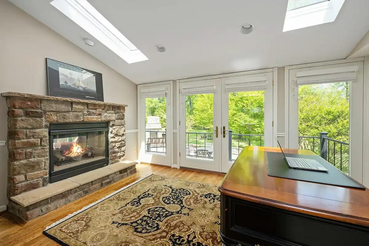 private office that overlooks back patio with fireplace