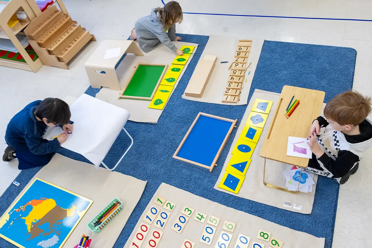 kindergarten students color and do activities in a classroom
