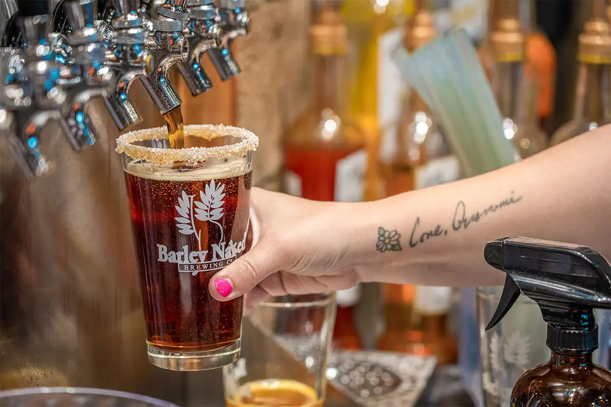 Person pouring draft beer into cup