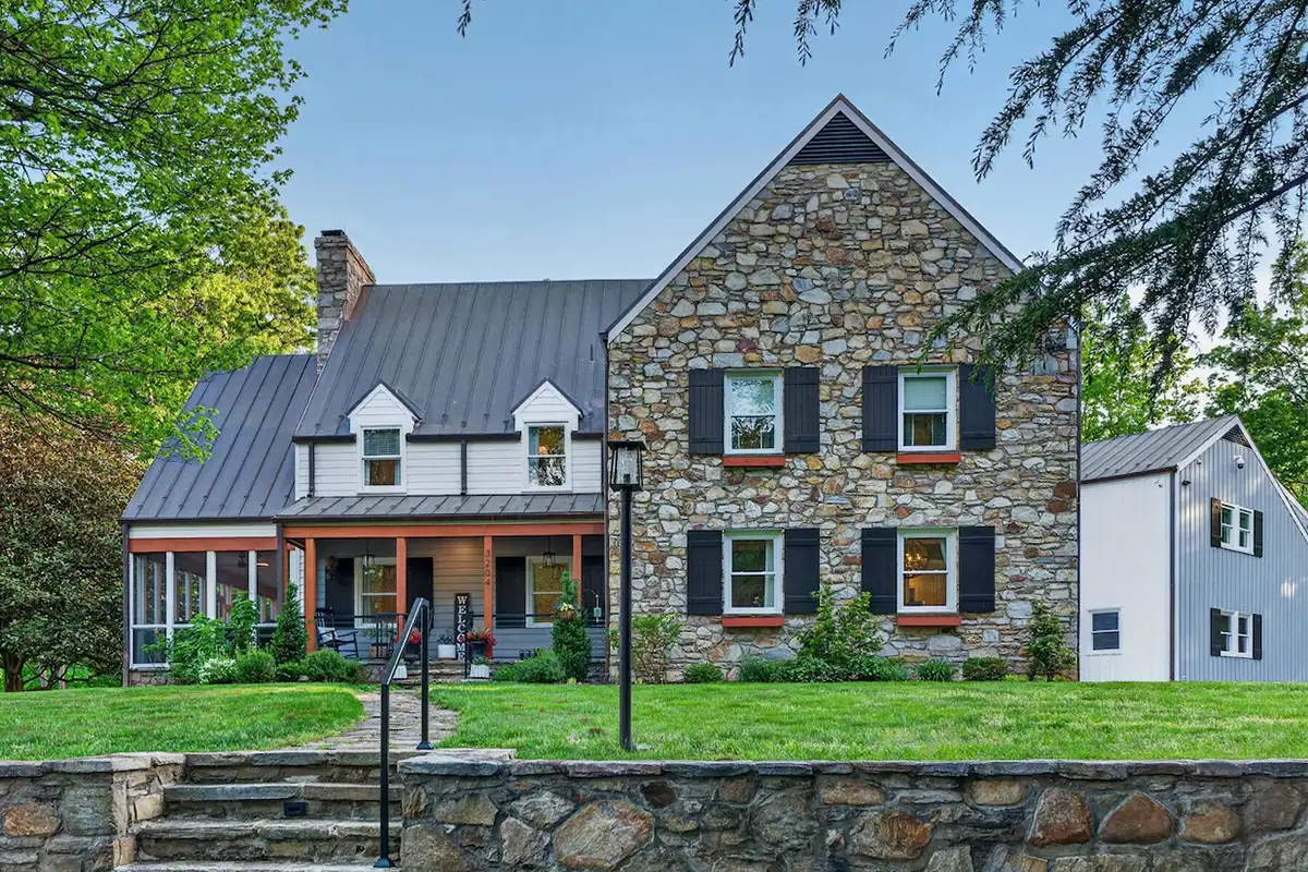 Exterior of 3204 Mountain Rd with copper roof, cedar siding, and hand-laid stone walls.