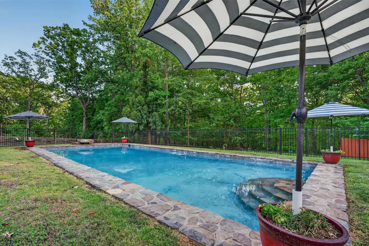Pool with stone detailing and umbrellas of 3204 Mountain Rd