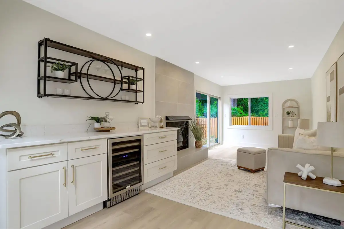 Second living/entertaining area with fireplace, cabinets, wine cooler, couches and chairs, and sliding doors of 3504 Gordon St