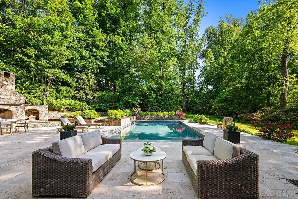 Backyard with 40x20 in-ground swimming pool, cabana with outdoor kitchen, grill, sink, icemaker, and fridge, and large stone fireplace of 4614 36th St N