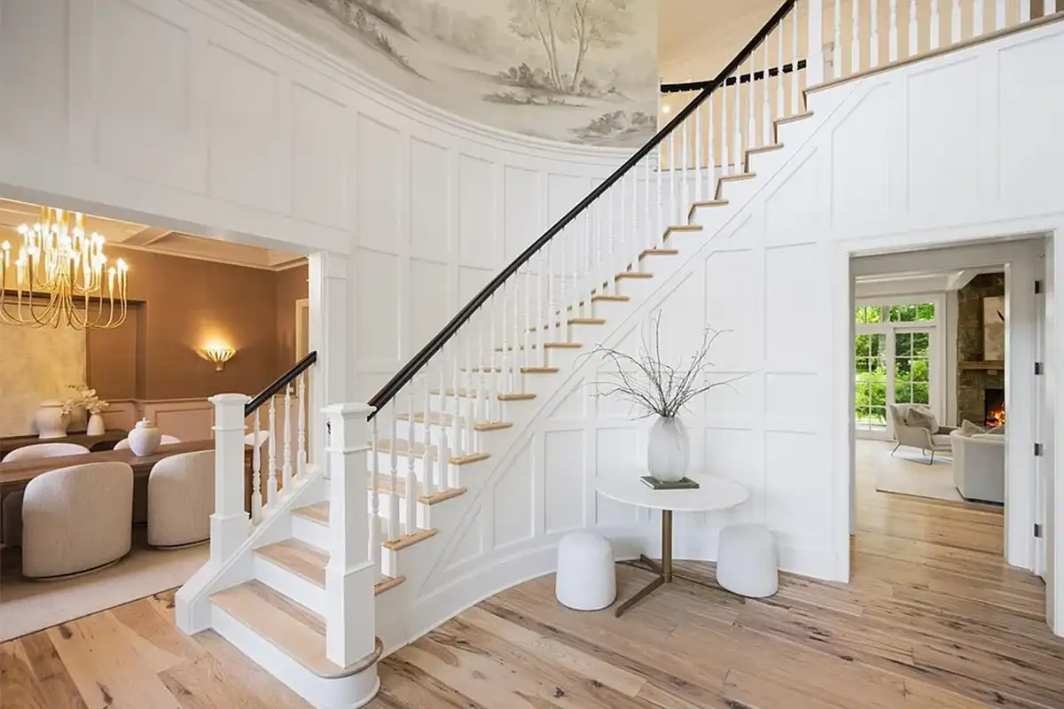 Foyer with grand staircase, wall paneling, and black and white wallpaper of 4614 36th St N
